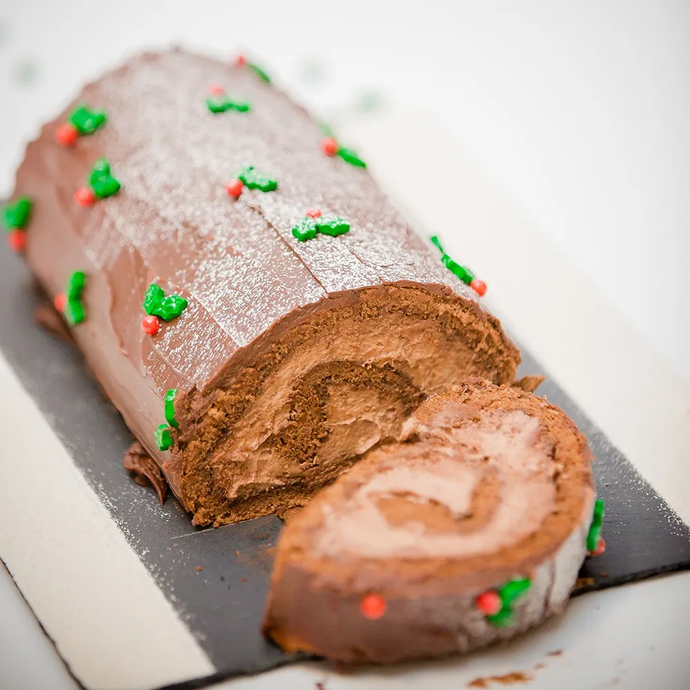 Finished chocolate yule log dusted with icing sugar