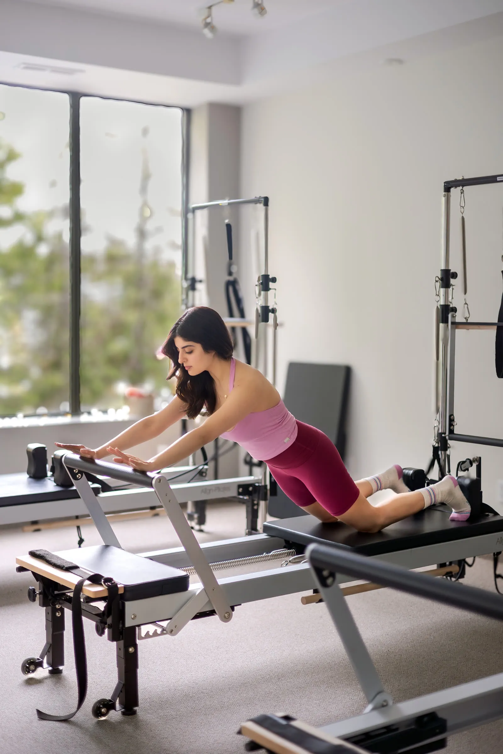 Juhi Sharma on a Reformer by a window